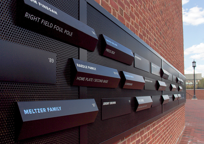 Dimensional donor and wayfinding signage panels on an exterior brick wall